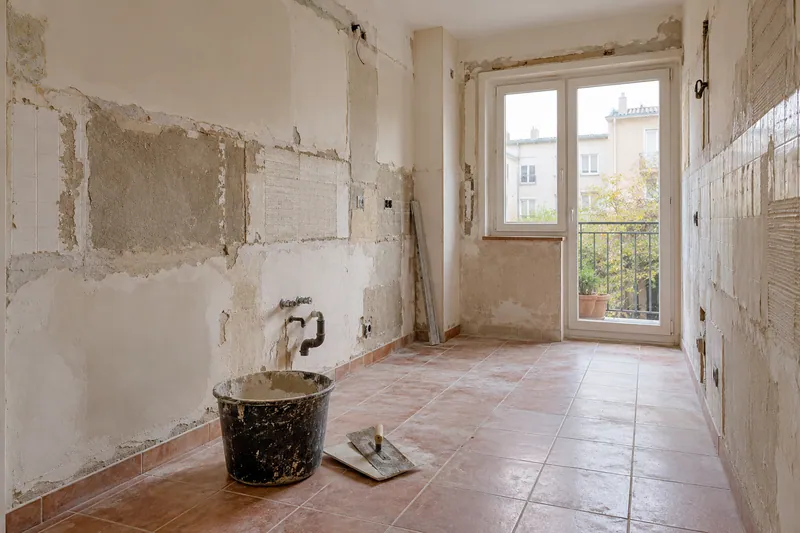 Visualización conceptual IA: Cocina sin muebles con paredes en preparación y zonas de enlucido.
